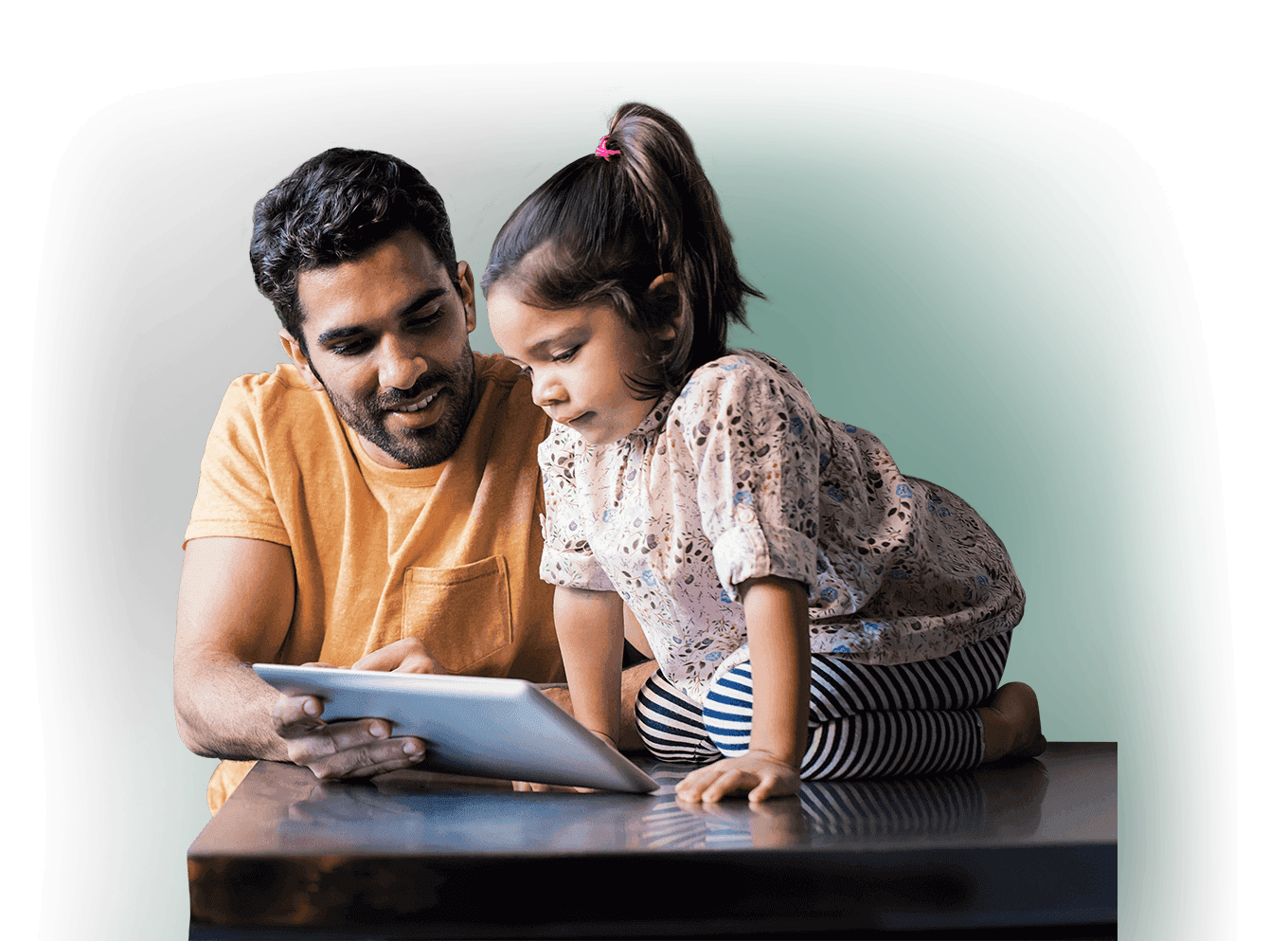 Father and young daughter reading from a tablet computer