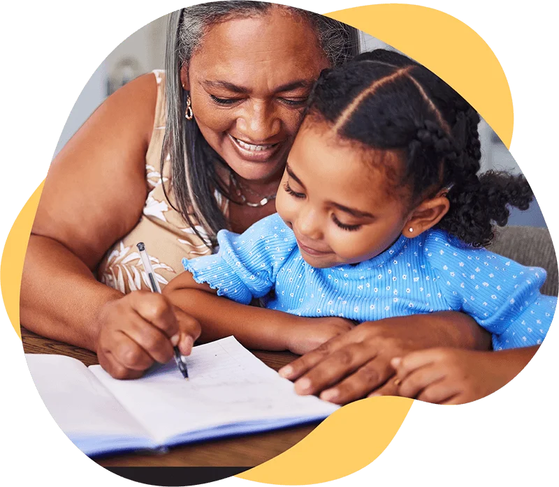 Mother teaching her young daughter while writing in her book