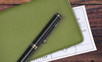 A pen resting on a checkbook